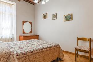 a bedroom with a bed and a mirror and a chair at Casa Luana in Lucignano