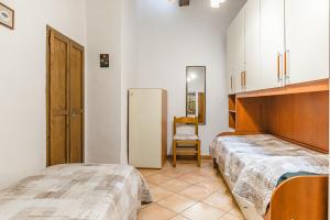 a bedroom with two beds and a chair in it at Casa Luana in Lucignano +22 photos