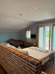 a bedroom with a brick wall and a bed at Kaya Amari in Fethiye