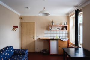a kitchen with a table and a blue couch in a room at Fabrik Gästehaus in Neustrelitz