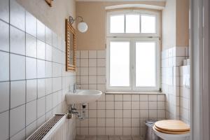 a bathroom with a sink and a toilet and a window at Fabrik Gästehaus in Neustrelitz