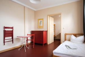 a bedroom with a bed and a table and a chair at Fabrik Gästehaus in Neustrelitz