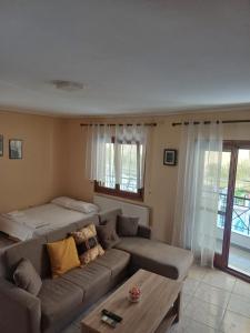 a living room with a couch and a bed at LA.KI House in Kavála