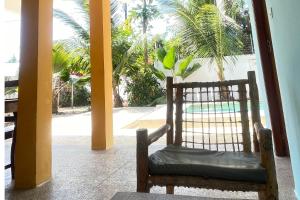 ein Stuhl in einem Zimmer mit Blick auf einen Pool in der Unterkunft Sabali Lodge, Zanzibar in Jambiani
