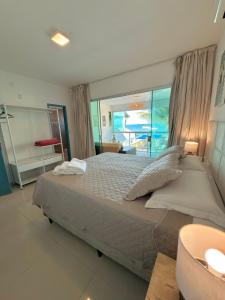 a bedroom with a large bed with a view of the ocean at Brisa de Barra Grande Beach House Pé na Areia in Maragogi +41 photos