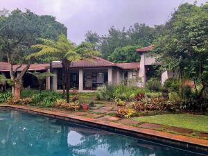 a house with a swimming pool in front of it at Ambience Inn White River in White River