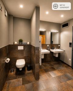 a bathroom with two sinks and a toilet at Eastside Braunlage in Braunlage +31 photos