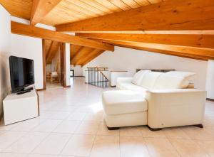 a living room with a white couch and a flat screen tv at Dolce Vita LakeView - By Turidea in Sale Marasino