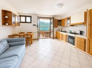 a kitchen and living room with a couch and a table at Dolce Vita LakeView - By Turidea in Sale Marasino