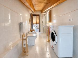 a bathroom with a washing machine and a toilet at Dolce Vita LakeView - By Turidea in Sale Marasino +4 photos