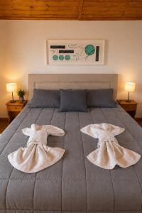 a large bed with two large pillows on it at Cabañas Caranday in Capilla del Monte