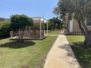 a sidewalk next to a house with two trees at Verter Home B&B in Ovile la Marina