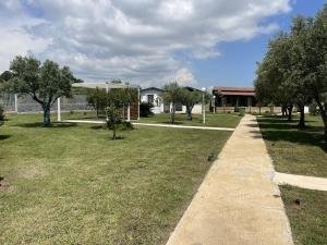 a sidewalk in a park with trees and a building at Verter Home B&B in Ovile la Marina +5 photos