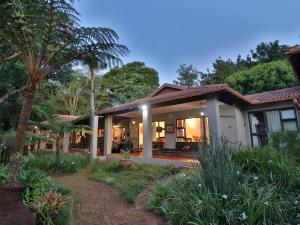 a house with a palm tree in front of it at Ambience Inn White River in White River