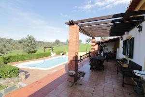 a patio with a swimming pool and a house at Quinta Moinho Meirinho in Crato