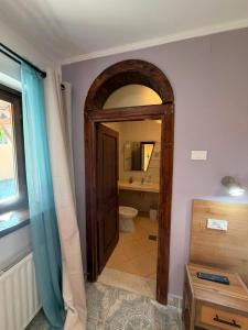 a bathroom with a toilet and a door with a mirror at La umbra nucului bătrân in Ghimbav