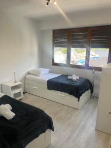 a bedroom with two beds and a window at Appartement la Liberté in Albertville