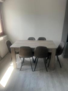 a wooden table with four chairs around it at Appartement la Liberté in Albertville