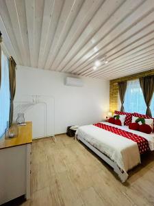 a bedroom with a large bed with red pillows at VarázsLakos Birtok in Tázlár +58 photos