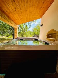 a large bath tub in a room with a window at VarázsLakos Birtok in Tázlár