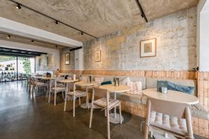 a restaurant with tables and chairs and a brick wall at K-Kanne in Kanne +60 photos