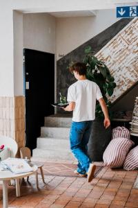 a man holding a plate of food on the stairs at K-Kanne in Kanne