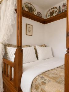 a bedroom with a wooden bed with white sheets at Rou Garden House in Karpathos +33 photos
