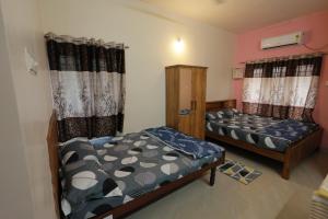 a room with two beds in a room at SITER Holidays Villa in Kovalam