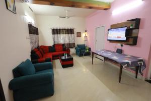 a living room with a couch and a table and a tv at SITER Holidays Villa in Kovalam