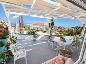 a patio with a table and chairs and plants at Rou Garden House in Karpathos