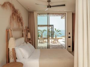a bedroom with a bed and a view of the ocean at Gaia Place in Agios Nikolaos