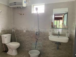 a bathroom with a toilet and a sink at Nest hill retreat in Mù Cang Chải +15 photos