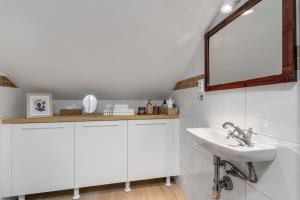 a bathroom with a sink and a mirror at Apartmán TICHO - Ostrůvek in Lesná