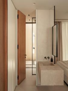a bathroom with a sink and a bed and a mirror at Gaia Place in Agios Nikolaos