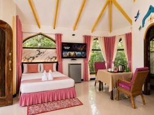 a bedroom with two beds and a table and chairs at MG Chateau Resort in El Nido