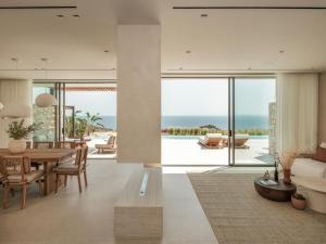 a living room with a dining table and a view of the ocean at Gaia Place in Agios Nikolaos