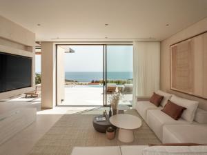 a living room with a white couch and a tv at Gaia Place in Agios Nikolaos +15 photos