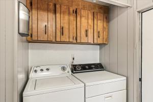 a washer and dryer in a small kitchen with wooden cabinets at Cozy Desert Hideaway in Tucson