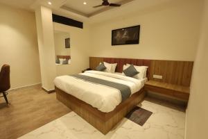 a bedroom with a large bed in a room at Yu Hotel in Kānpur