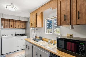 a kitchen with white appliances and wooden cabinets at Cozy Desert Hideaway in Tucson