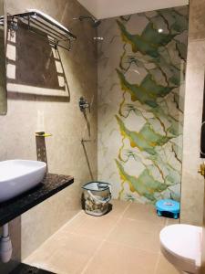a bathroom with a shower and a sink at Yu Hotel in Kānpur