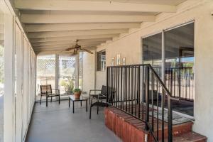 a porch with chairs and a table and windows at Cozy Desert Hideaway in Tucson +11 photos