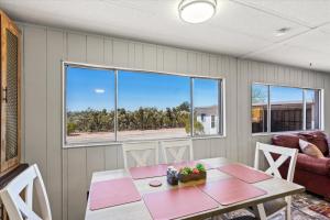a room with a table and chairs and windows at Cozy Desert Hideaway in Tucson