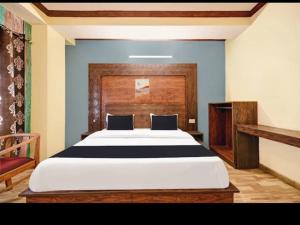 a bedroom with a large bed with a wooden headboard at Tara Regency Hotel in Shimla