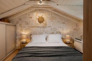 a bed in a room with a stone wall at Casa Falco in Vasilikos +29 photos