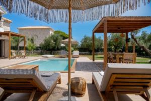 a villa with a swimming pool and an umbrella at Casa Falco in Vasilikos