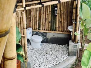 a bathroom with a toilet in a bamboo fence at Rafka Bamboo Valley in Seribatu