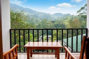 a balcony with a table and a view of the mountains at MOUNT PLEASANT ELLA in Ella