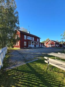 a red barn with two benches in front of it at Turistgården Töcksfors in Töcksfors