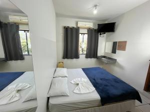 a bedroom with a bed and a tv and windows at Hotel Palace Huesca in Presidente Prudente